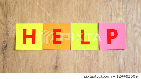 Help symbol. Concept word Help on beautiful colored paper. Beautiful wooden table wooden background. Business, lifestyle, support and help concept. Copy space. 124492509