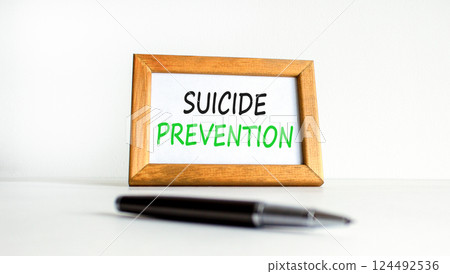 Suicide prevention symbol. Concept words Suicide prevention on beautiful wooden picture frame. Black pen. Beautiful white background. Psychological suicide prevention concept Copy space Suicide prevention symbol. Concept words Suicide prevention on beautiful wooden picture frame. Black pen. Beautiful white background. Psychological suicide prevention concept Copy space 124492536