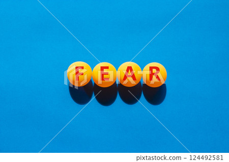 Fear symbol. Concept word Fear on beautiful yellow ping pong balls. Beautiful blue table blue background. Business, lifestyle and fear concept. Copy space. 124492581
