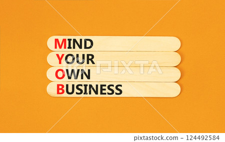 MYOB mind your own business symbol. Concept word MYOB Mind Your Own Business on beautiful wooden sticks. Beautiful orange background. Business MYOB mind your own business concept. Copy space. 124492584