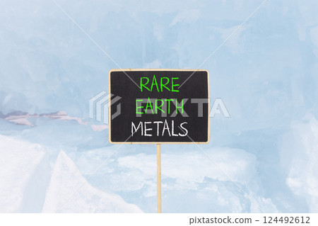 Rare earth metals symbol. Concept words Rare earth metals on beautiful blackboard. Beautiful blue ice and snow background. Business and rare earth metals concept. Copy space. 124492612