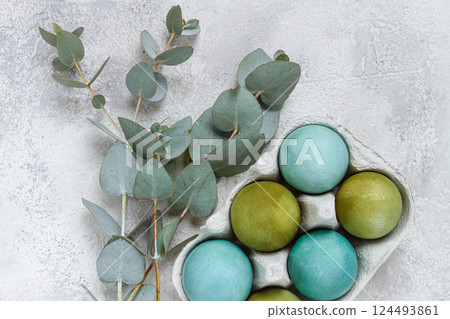 Easter colored eggs, in green and turquoise tones, with eucalyptus leaves, Easter card, top view, no people, 124493861