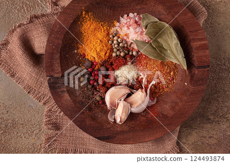 spice mix, garlic and bay leaf, on a wooden plate, close-up, food concept, no people, 124493874