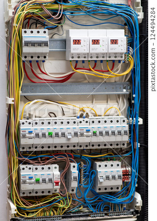 Electrical panel with circuit breakers, wiring, and voltage indicators. Industrial power distribution system 124494284
