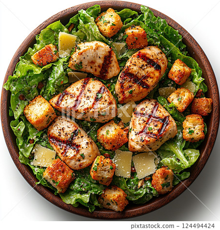 Delicious chicken caesar salad featuring grilled chicken, croutons, and parmesan cheese in a wooden bowl. 124494424