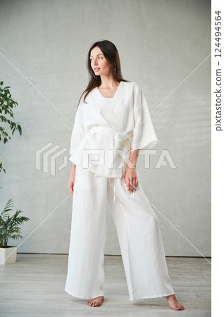 Studio portrait of beautiful happy woman in white attire before Thai massage. Studio portrait of beautiful happy woman in white attire before Thai massage. 124494564