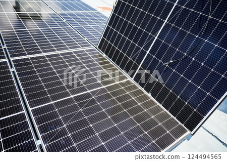 Solar photovoltaic panels on rooftop. Installation of solar batteries on top of modern house. Concept of alternative energy sources in modern life. Solar photovoltaic panels on rooftop. Installation of solar batteries on top of modern house. Concept of alternative energy sources in modern life. 124494565