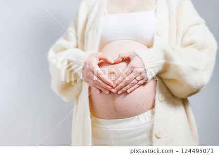 Pregnant woman holding her hand on her stomach Heart 124495071