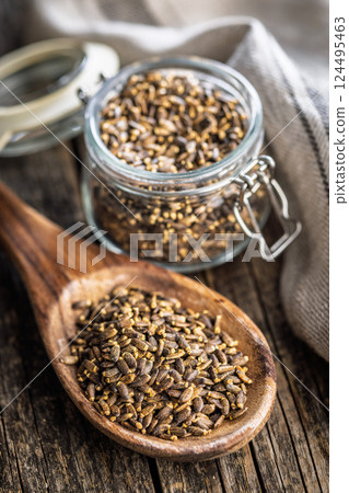Milk thistle seeds on wooden spoon on wooden table. Milk thistle seeds on wooden spoon on wooden table. 124495463