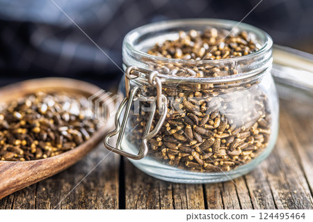Milk thistle seeds in jar on wooden table. Milk thistle seeds in jar on wooden table. 124495464