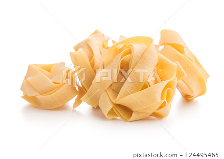 Italian pasta tagliatelle. Uncooked noodle pasta isolated on white background. Italian pasta tagliatelle. Uncooked noodle pasta isolated on white background. 124495465