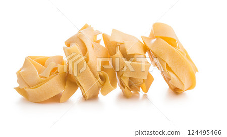 Italian pasta tagliatelle. Uncooked noodle pasta isolated on white background. Italian pasta tagliatelle. Uncooked noodle pasta isolated on white background. 124495466