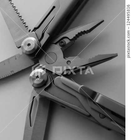 Grayscale Photo of Universal Multi Tool with Open Knife, Saw and Rope Cutter Isolated Grayscale Photo of Universal Multi Tool with Open Knife, Saw and Rope Cutter Isolated 124495816