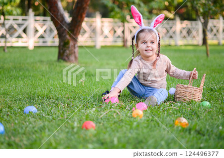 Children Hunting Easter Eggs in the Garden with Bunny Ears Children Hunting Easter Eggs in the Garden with Bunny Ears 124496377