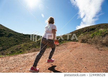 Caucasian child running on mountain trail under bright sunlight Caucasian child running on mountain trail under bright sunlight 124496526