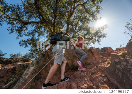 Young caucasian couple hiking on rocky terrain under sunny sky Young caucasian couple hiking on rocky terrain under sunny sky 124496527