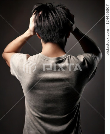 Back view of a young man holding his head 124496807