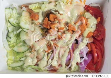 Top view of chicken salad full of fresh vegetables in a carton. Top view of chicken salad full of fresh vegetables in a carton. 124497005