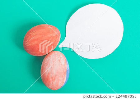 Colorfully painted eggs and a speech bubble on a vibrant green background. Colorfully painted eggs and a speech bubble on a vibrant green background. 124497053