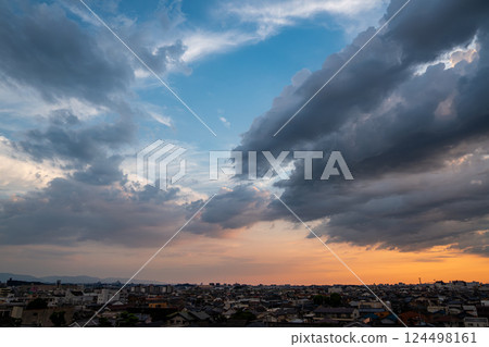 A city enveloped in spreading clouds and a sunset 124498161
