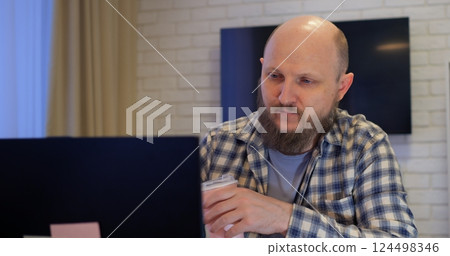 Remote Job. A man is working with documents on laptop remotely at home. A business man is using computer and typing text on the keyboard. Quarantine and isolation concept Remote Job. A man is working with documents on laptop remotely at home. A business man is using computer and typing text on the keyboard. Quarantine and isolation concept 124498346