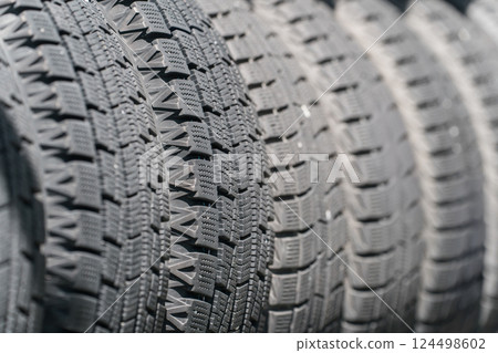 Tires lined up on a tire rack 124498602