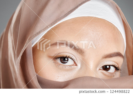 Muslim, eye and beauty with face of woman for health lashes, makeup and vision in grey background. Youth, cosmetics and skincare with islamic girl and zoom in stare for hijab, serious or religion Muslim, eye and beauty with face of woman for health lashes, makeup and vision in grey background. Youth, cosmetics and skincare with islamic girl and zoom in stare for hijab, serious or religion 124498822