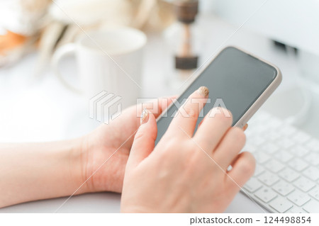 一名女子用指甲觸摸智慧型手機螢幕 一名女子用指甲觸摸智慧型手機螢幕 124498854