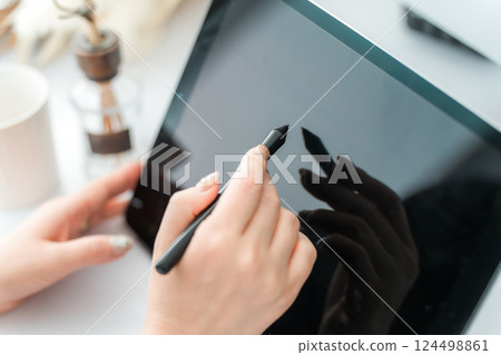 A woman drawing something on a tablet PC using a pen tablet (manga artist, creator, designer, animator) 124498861