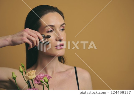 Beauty routine with facial rollers and flowers in a warm setting 124499157