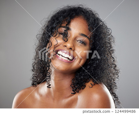 Black woman, beauty and hair in face, makeup or smile against studio background with happiness. Model, hair care and happy with cosmetics for skincare, self care or portrait with glow, skin or curly 124499486