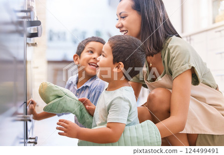 Family kids bonding, baking and mother happy at a kitchen oven spending quality time. Mama and children smile together with love and care learning to cook at a house with happiness making food 124499491