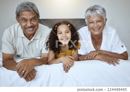 Happy, grandparents and child lying on bed with smile for family bonding, retirement and relax at home. Portrait of little girl, grandma and grandpa smiling in bedroom relaxing together for childcare Happy, grandparents and child lying on bed with smile for family bonding, retirement and relax at home. Portrait of little girl, grandma and grandpa smiling in bedroom relaxing together for childcare 124499495