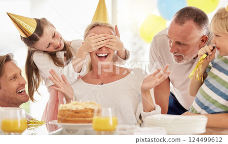Surprise, birthday cake and mother with family for celebration, party and excited people. Happiness, love and big family with children cover mom eyes to celebrate mothers day holiday together 124499612