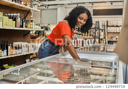 Woman, grocery food shopping and freezer store product of supermarket looking for a discount, sale or special retail offer. Healthy, nutritious and delicious meal for cooking lunch or dinner at home 124499719