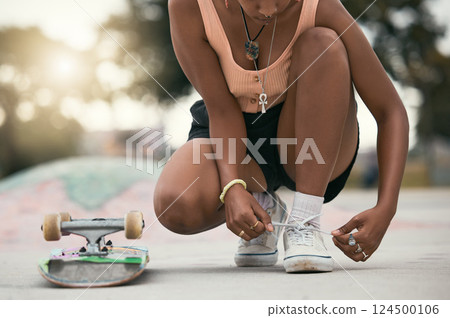 Skater, shoes and tying laces with skateboard in park to skate for fun, exercise and training outdoors. Fitness, woman athlete and sports sneakers on feet in park during summer vacation or adventure. 124500106