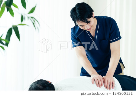 A male chiropractor performing a treatment 124500131