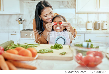 Mother, child and have fun cooking in kitchen together with teamwork to cut chillies, peppers and vegetables on counter for lunch. Happy, girl with smile and mom teach kid healthy food recipe at home 124500363