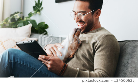 Home, dog and man with tablet, smile and relax with social media, laughing and communication. Apartment, person and guy on sofa, tech and best friend with pet, happiness and website info for animals 124500623