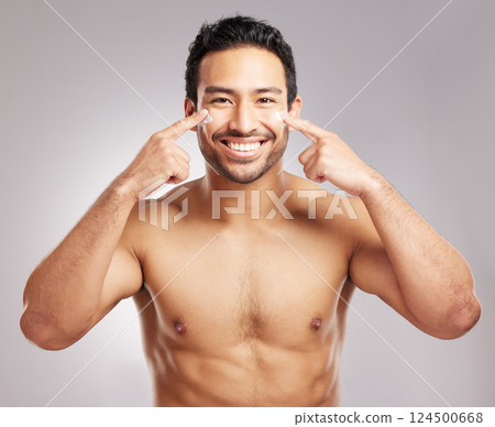 Beauty, cream and portrait of man in studio to apply moisturizer for cosmetics or dermatology routine. Aesthetic, lotion and skincare with happy shirtless model on gray background for cosmetology Beauty, cream and portrait of man in studio to apply moisturizer for cosmetics or dermatology routine. Aesthetic, lotion and skincare with happy shirtless model on gray background for cosmetology 124500668