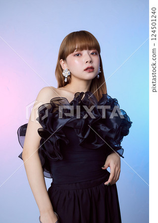 Portrait of a female model wearing a black ruffled dress 124501240