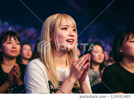 A woman watching a live performance with fascination A woman watching a live performance with fascination 124501405