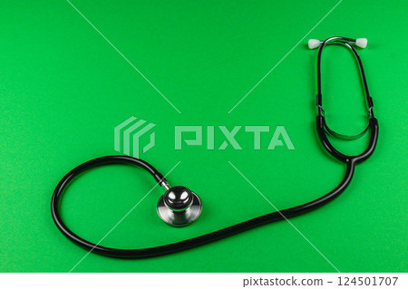 Stethoscope resting on bright green surface Stethoscope resting on bright green surface 124501707