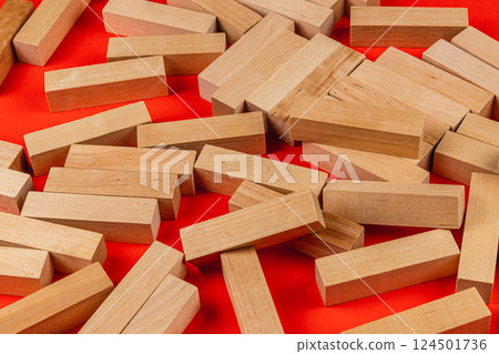 Wooden blocks scattered on a red surface Wooden blocks scattered on a red surface 124501736