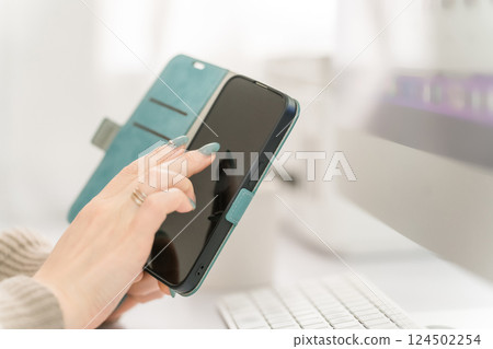 一名女子用指甲觸摸智慧型手機螢幕 一名女子用指甲觸摸智慧型手機螢幕 124502254