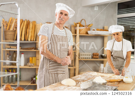 Two experienced chefs prepare dough on the kitchen table of private bakery Two experienced chefs prepare dough on the kitchen table of private bakery 124502316