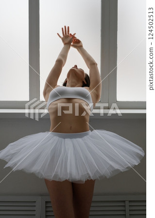 Elegant woman in lingerie practicing ballet in a bright dance studio 124502513