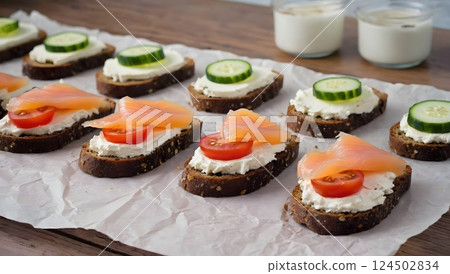 Fresh organic homemade smorrebrod with cereals dark rye grain bread toasts, salted salmon on dark grey rustic wooden table background. Healthy lifestyle breakfast. Traditional Danish open sandwich. Fresh organic homemade smorrebrod with cereals dark rye grain bread toasts, salted salmon on dark grey rustic wooden table background. Healthy lifestyle breakfast. Traditional Danish open sandwich. 124502834