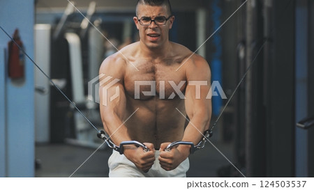 Muscular man workout in gym doing exercises for chest, cable crossover. Strong male naked torso abs. 124503537