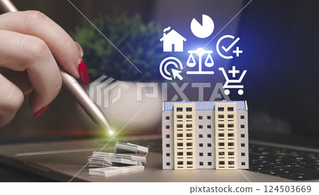 hand using a stylus interacts with a virtual apartment building model on a laptop, symbolizing online real estate investment and fintech. 124503669